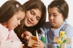 Three young people working on a Bible themed craft.