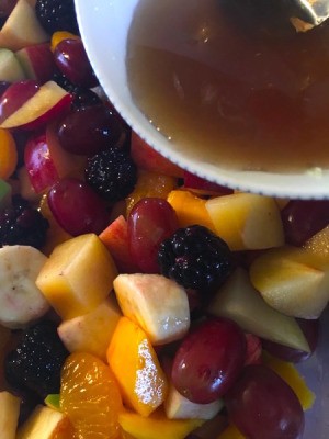 Fruit Salad with Maple Lime Dressing - pouring dressing on fruit