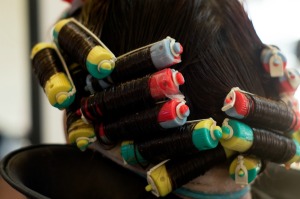 A woman in the middle of getting a perm at a salon.