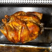 A chicken being cooked in a home rotisserie.