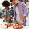 Couple making pizza together at home.