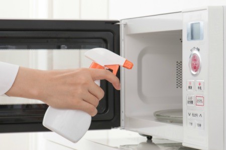 Cleaning solution being sprayed into a microwave.