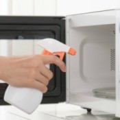 Cleaning solution being sprayed into a microwave.