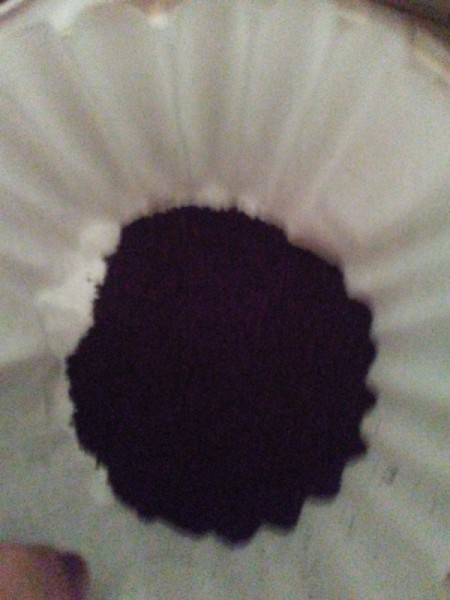 The contents of a K-cup inside a paper coffee filter.