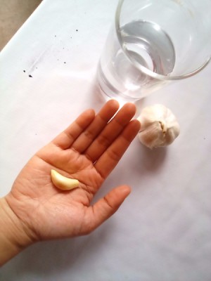 A clove of garlic in a person's hand.