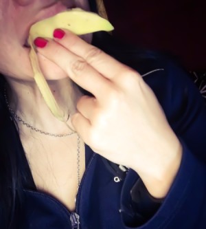 Banana Peel Tooth Whitener - woman rubbing the inside of a banana peel on her teeth
