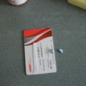A plastic card being used as a pill splitter.