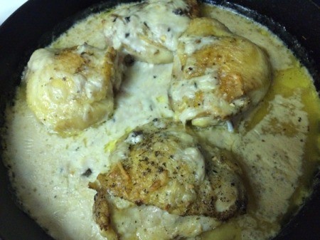 Soup mixture added to chicken in pan