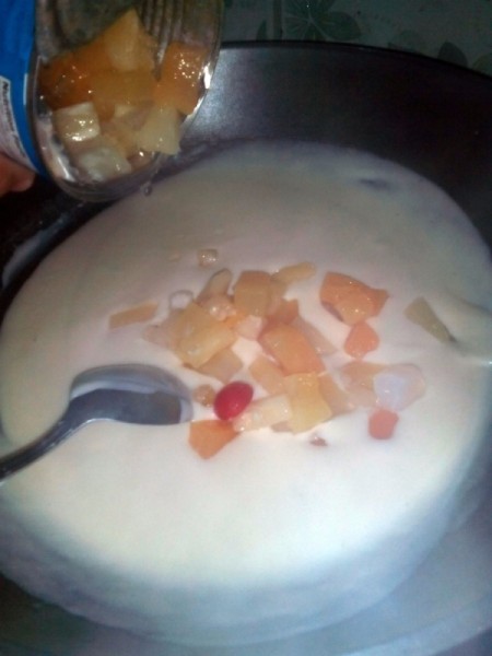 Adding fruit cocktail to pudding mixture