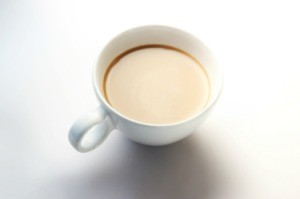 A cup of coffee with cream in it.