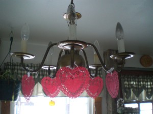 Heart Doily Valentine Decoration - red paper heart doilies hanging from light fixture