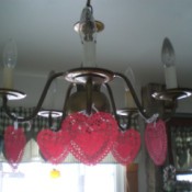 Heart Doily Valentine Decoration - red paper heart doilies hanging from light fixture