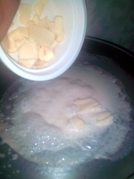 adding cheese to simmering milk