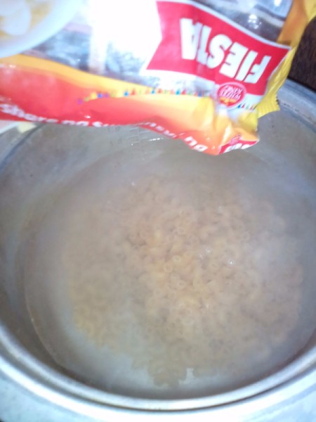 adding macaroni to soup