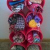 Using Coffee Tubs for Fabric Storage - stack of cans filled with fabric with a short piece of wood under the bottom row to give back tilt