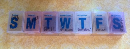 A weekly pill keeper with letters for the days of the week.