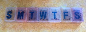 A weekly pill keeper with letters for the days of the week.