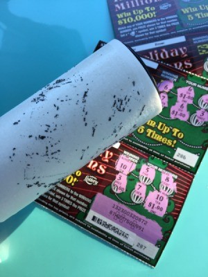 Using a lint roller on a scratch off lottery ticket.