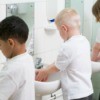 Children washing their hands in a school bathroom.