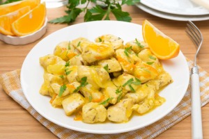 A dish of orange chicken on a table.