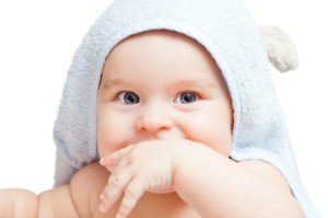 Baby wearing a light blue hooded towel.