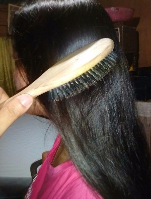 A woman brushing her long brown hair.