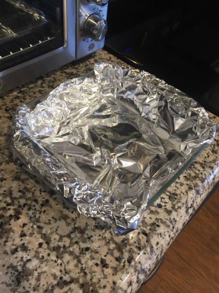 A glass baking pan lined with tinfoil