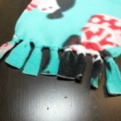 A fleece scarf with a penguin pattern on it.