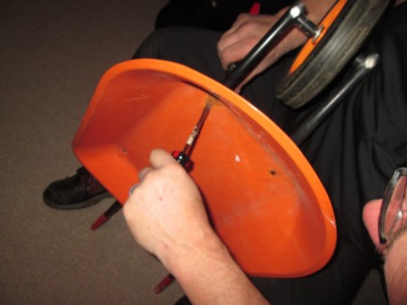 Toy Wheelbarrow as Flower Planter - using a screwdriver to take barrow apart