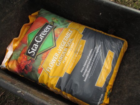 Toy Wheelbarrow as Flower Planter - bag of potting soil