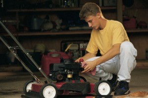 A teenager fixing a lawn mower.