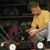 A teenager fixing a lawn mower.