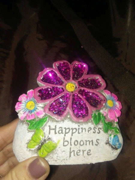 A flower sign that says "Happiness blooms here"