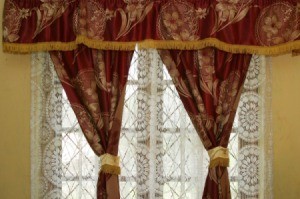 Ornate dry clean only drapes hanging in a window.