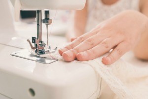 Hands using a sewing machine.