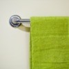 A towel rack with a green towel hanging on it.