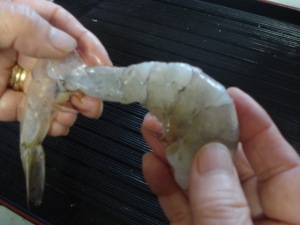 Removing the shell from a shrimp.