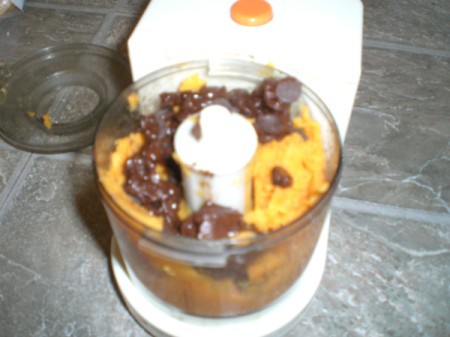 adding chocolate chips to sweet potatoes in processor
