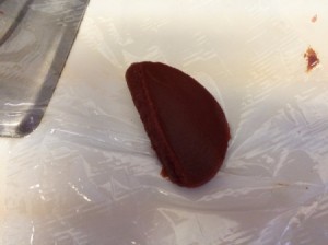 A blob of tomato paste on plastic wrap.