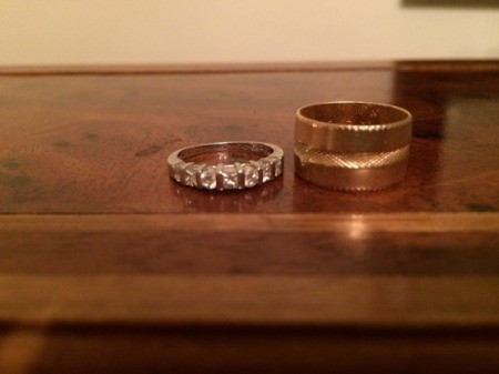 Wedding rings on a wooden dresser.