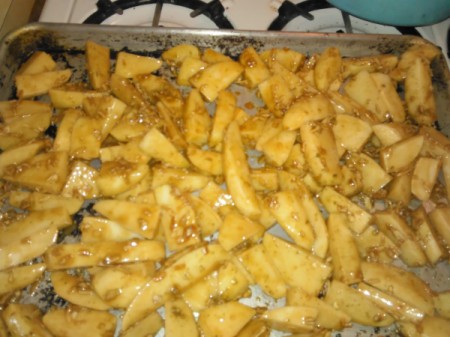 potato pieces spread on baking pan