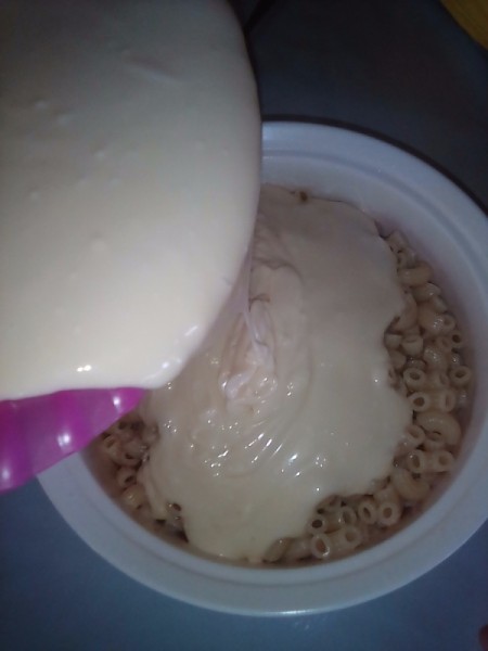 pouring cream mixture over macaroni