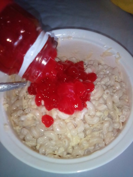 adding fruit to creamy macaroni