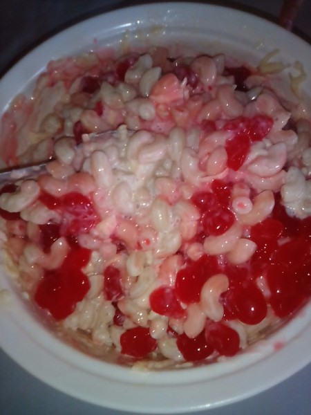 mixing fruit with creamy macaroni