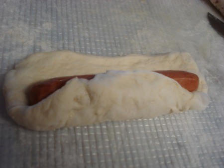 wrapping up hot dog in pizza dough
