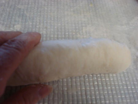 Hot dog in pizza dough ready to bake