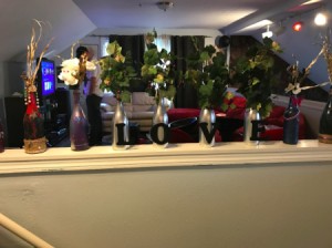 A row of differently decorated wine bottles.