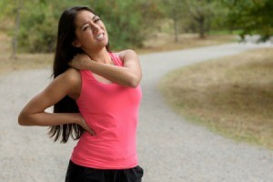 A runner with a muscle cramp in her shoulder.