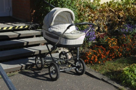 A used stroller outside near steps.