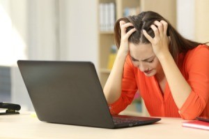 A frustrated woman looking at her laptop computer.